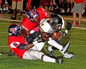 Linebackers A. J. Polk (left) and James Johnson (upper right) make the tackle on a Hernando runner during Thursday night’s match-up between the Tigers and Hernando. South Panola defeated Hernando 35-26. The Panolian photo by Andy Young