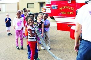 First grader Melanese Robertson is all smiles when she is given the opportunity to hold a real fire hose while touring the Batesville Fire Department Station 1 Wednesday. Students from Batesville Elementary School heard instructions on fire safety and saw demonstrations by firemen. This month firefighters will visit schools throughout the county. October is Fire Prevention Month. The Panolian photo by Emily Williams 