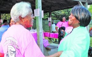 Cathryn Hyde (left) greets Maxine Gray at the Rubies and Roses Breast Cancer Awareness Walk Saturday morning at Pope School. The Panolian photo by Glennie Pou