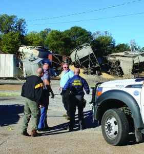 Assessing the aftermath of an 18-railcar derailment last Friday in Crenshaw are (from left) Terry Bryant of Panola County Emergency Operations, State Trooper Shane Phelps, an unidentified railway official, and State Trooper Troy Moses. See story, page A2. The Panolian photo by John Howell