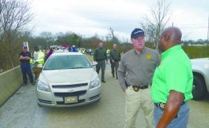 Sheriff Dennis Darby and Lt. Edward Dickson (left and right, foreground) discuss the strange sequence of events that unfolded on Panola Avenue Thursday morning.