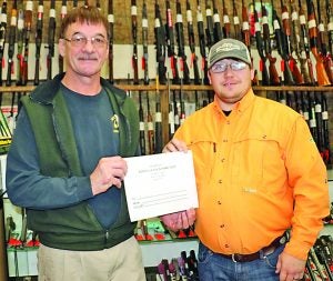 Cory Collins (right) was the second place winner in the Batesville Gun & Pawn Shop/Panolian Big Buck Contest. He received a $250 gift certificate from Kelvin Marshall. Collins won by a drawing for second place for his 10-point buck he bagged on December 3. The Panolian photos by Myra Bean